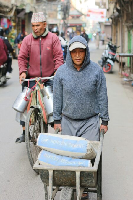 man pushing cement on a wheelbarrow