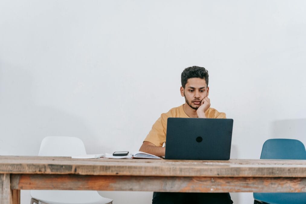 a man sitting with laptop on the table