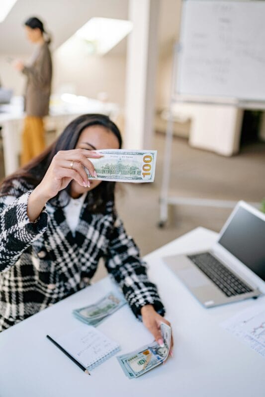 lady with money and laptop